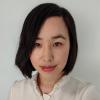 A woman with short black hair in a white shirt